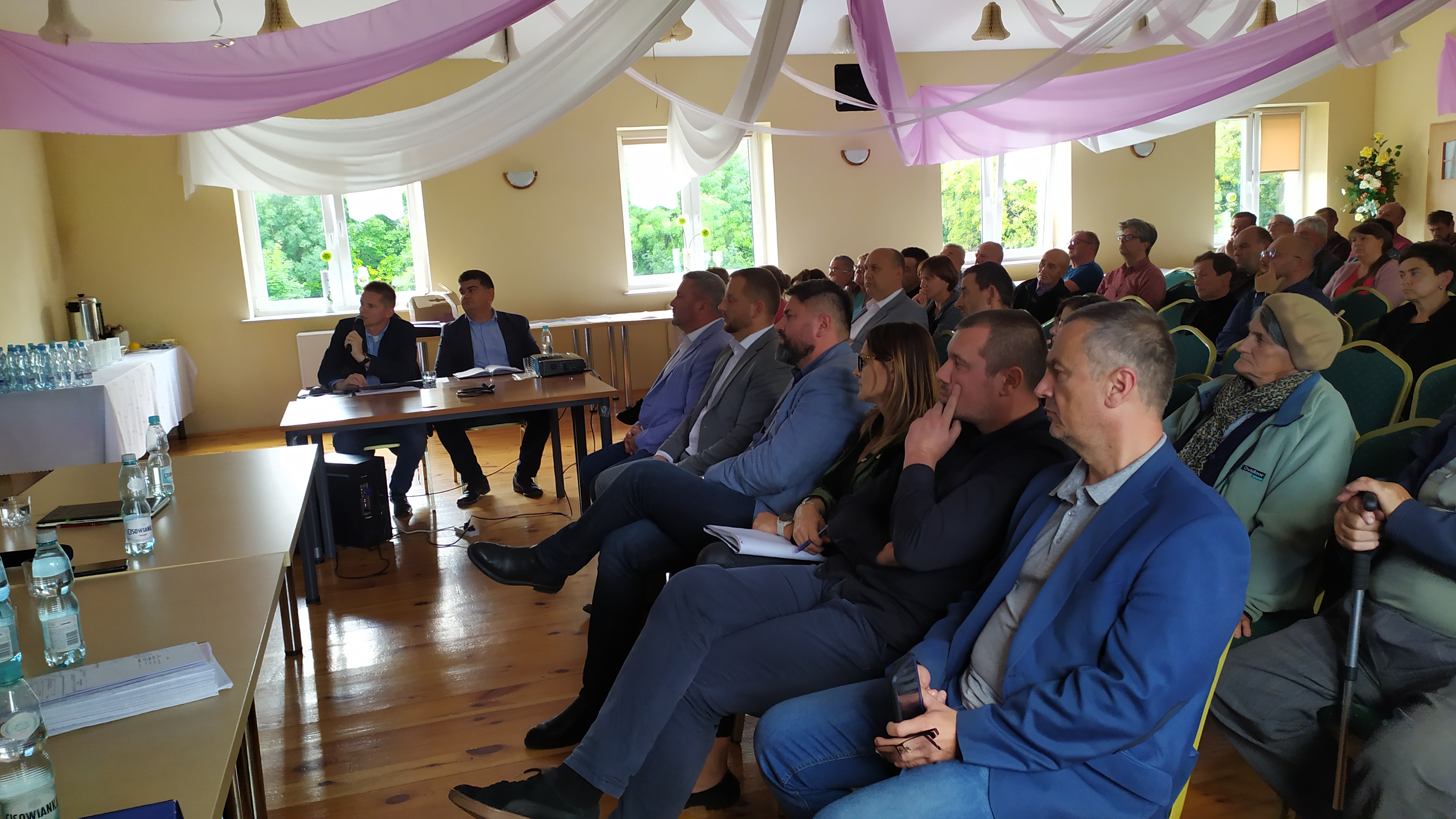 windowania ogląda prezentację, siedząc na zielonych krzesłach